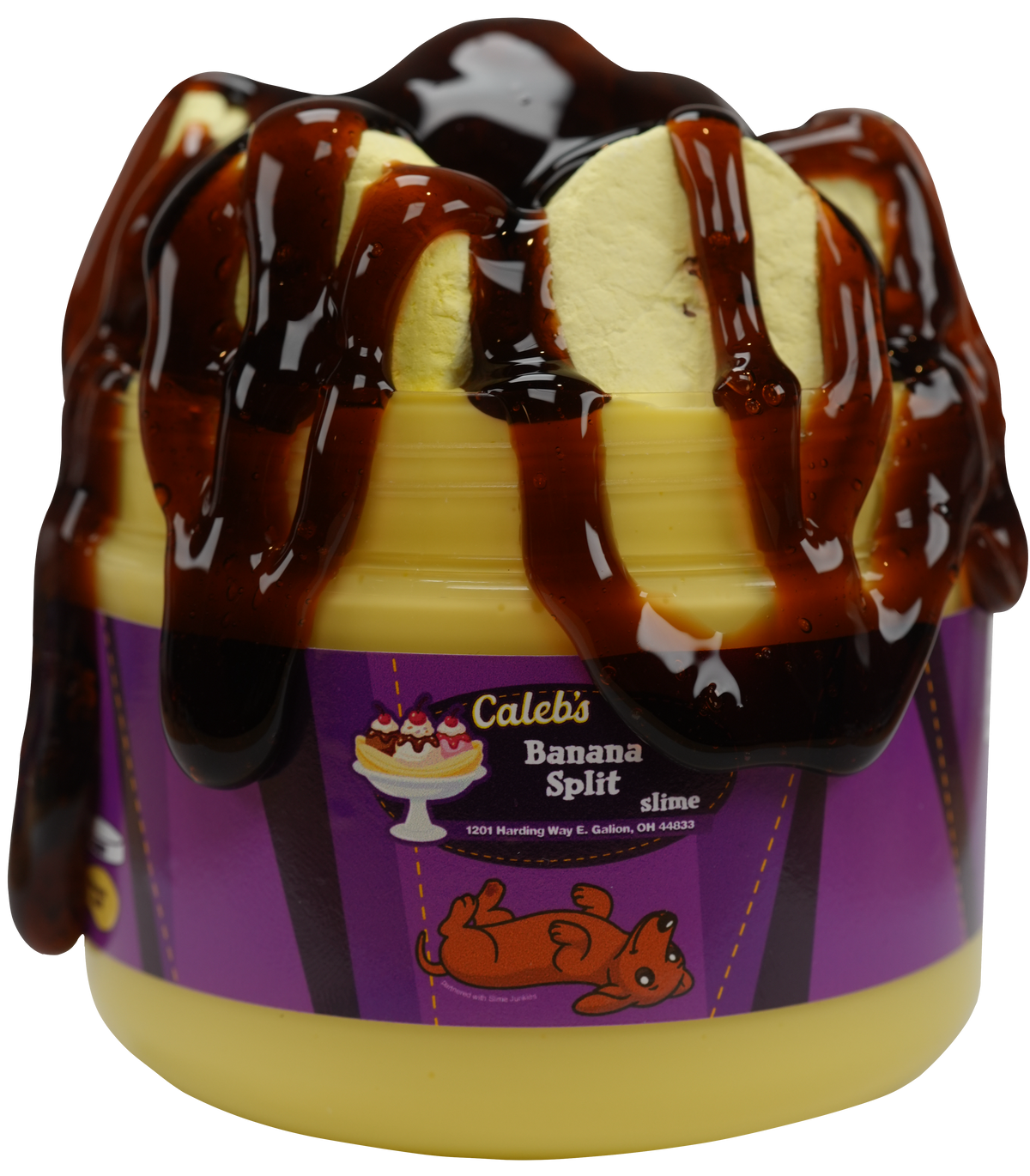 A banana split dessert slime with decorative stickers and logos. The product has a purple wrapper with a banana split illustration and is topped with chocolate drizzle and cream-colored elements.