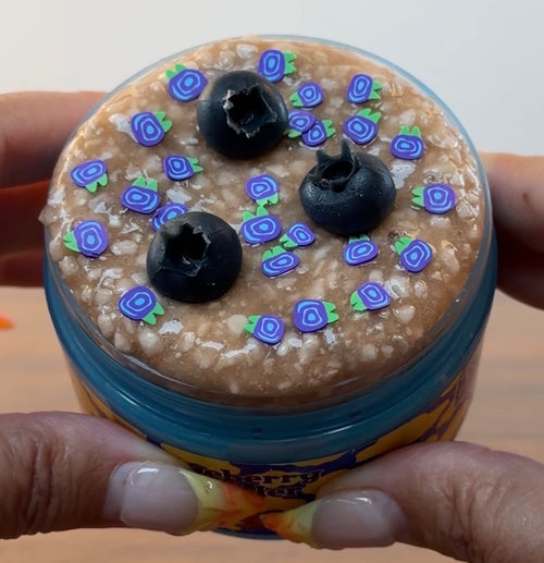 blue jelly slime with light tan perlite topper with fake plastic blueberries with fake blueberry sprinkles