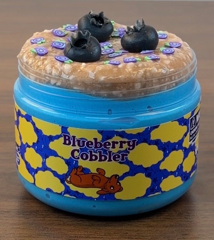 blue jelly slime with light tan perlite topper with fake plastic blueberries with fake blueberry sprinkles