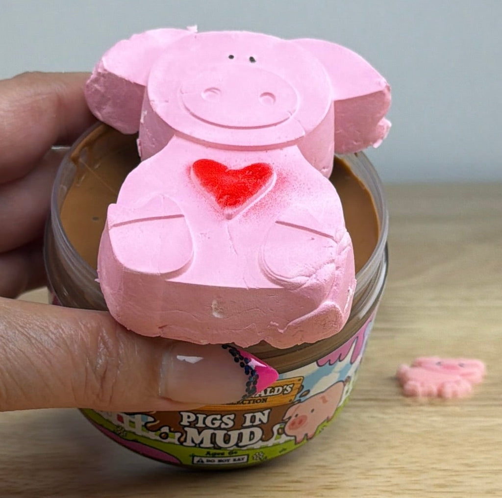 brown slime with a pig clay piece in a clear jar with an old macdonald farm collection farm label with a pig on it