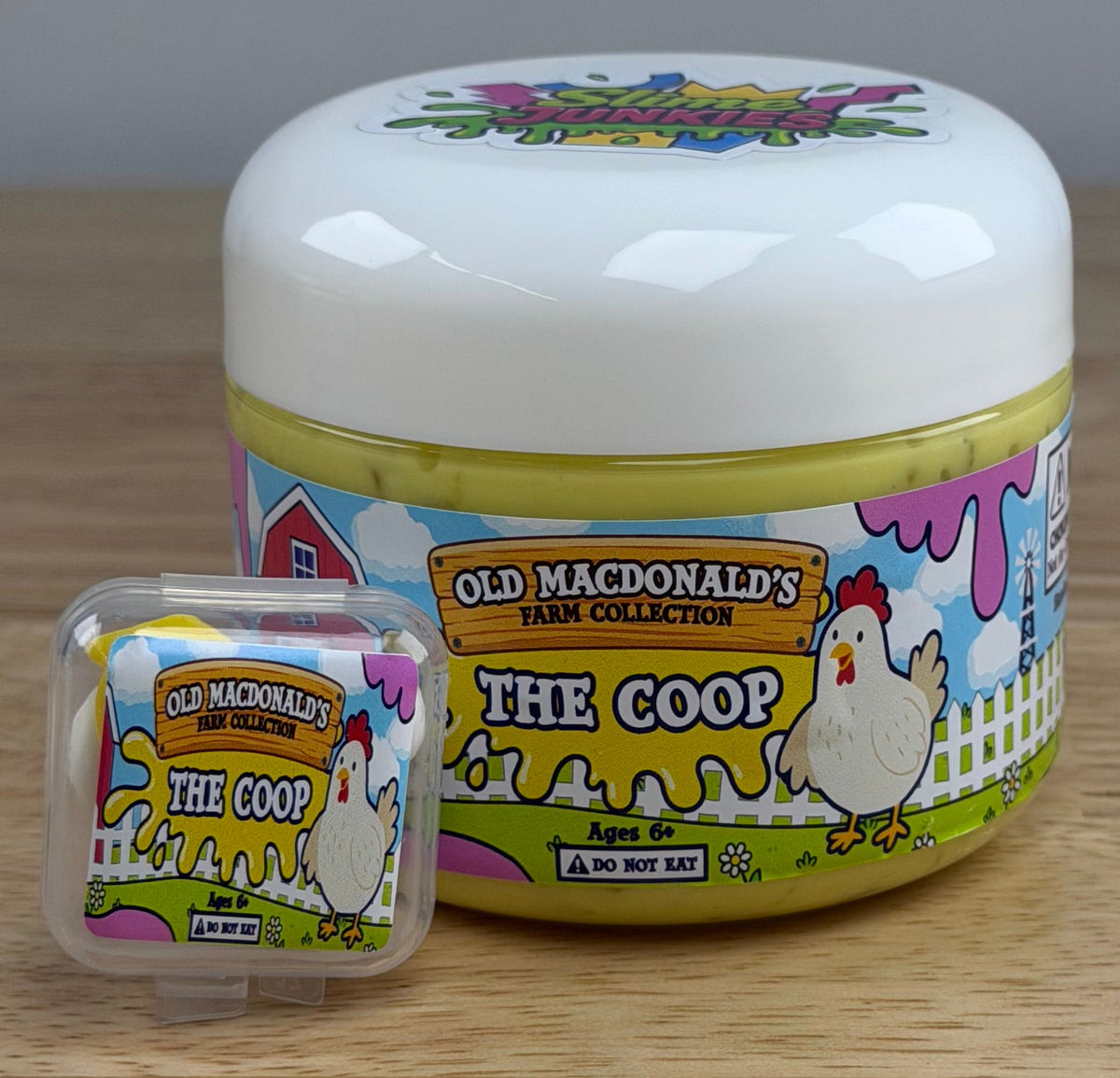 yellow slime with silica in a clear jar with a farm label that says old macdonald's farm collection the coop with a chicken topped with a chicken basket two eggs and a baby chicken