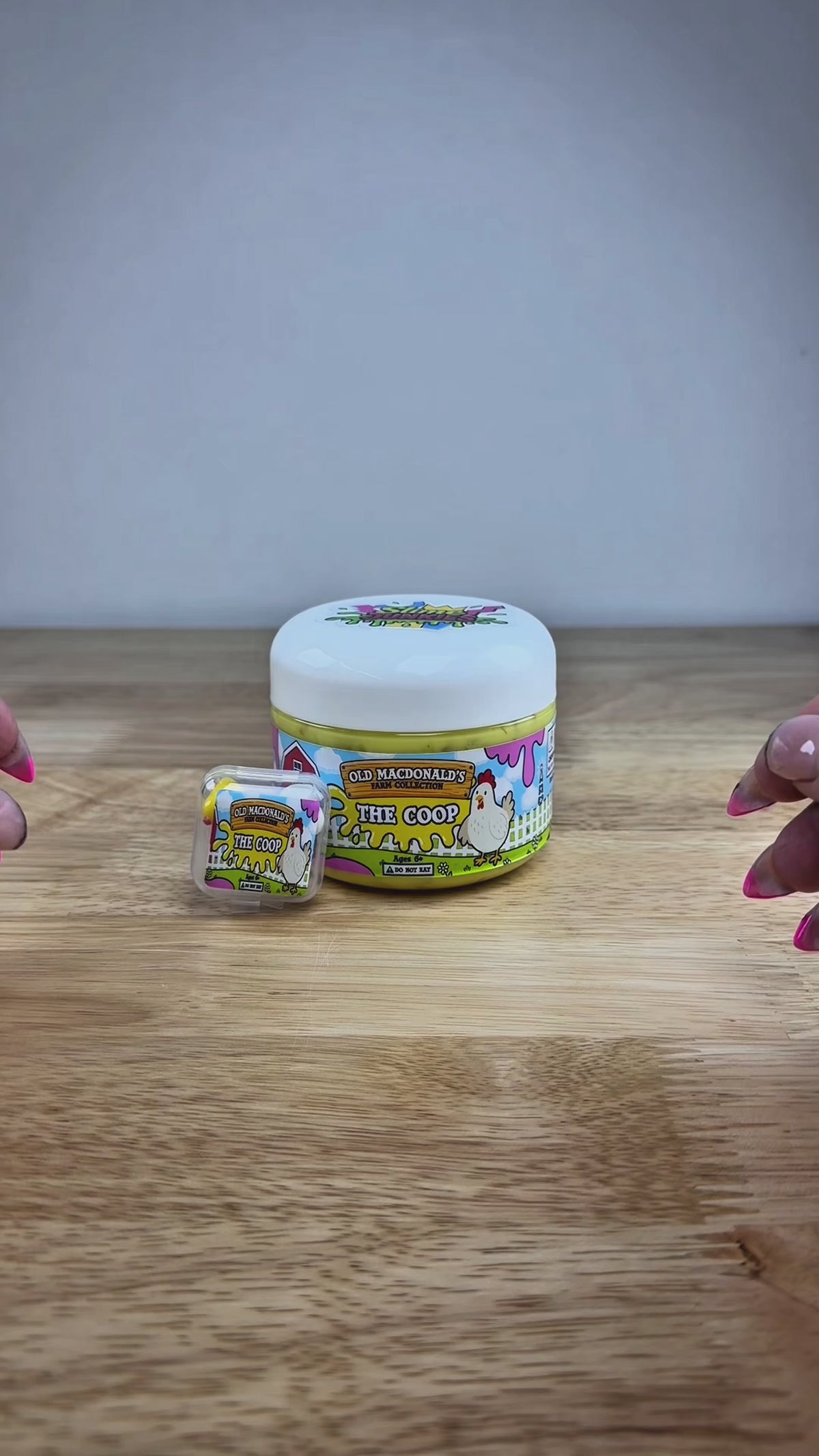 yellow slime with silica in a clear jar with a farm label that says old macdonald's farm collection the coop with a chicken topped with a chicken basket two eggs and a baby chicken