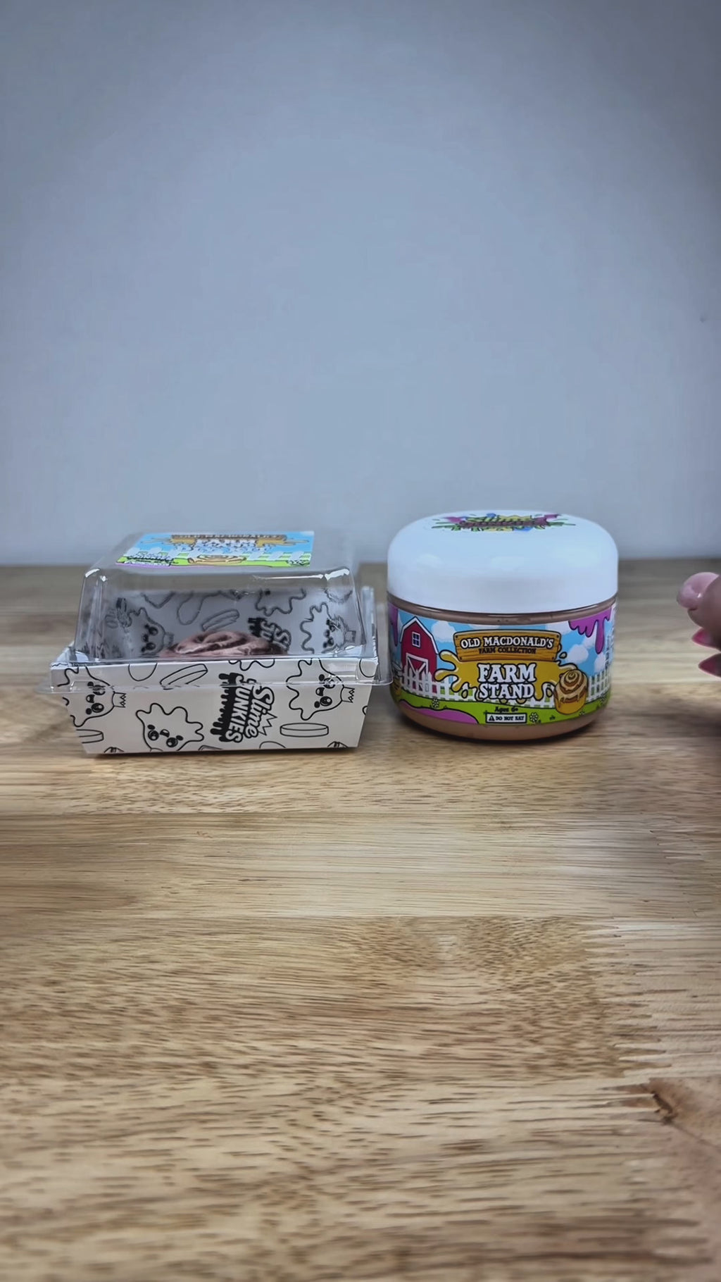 light tan slime in a clear jar with an old macdonald farm collection farm label that says farm stand with a cinnamon roll on it