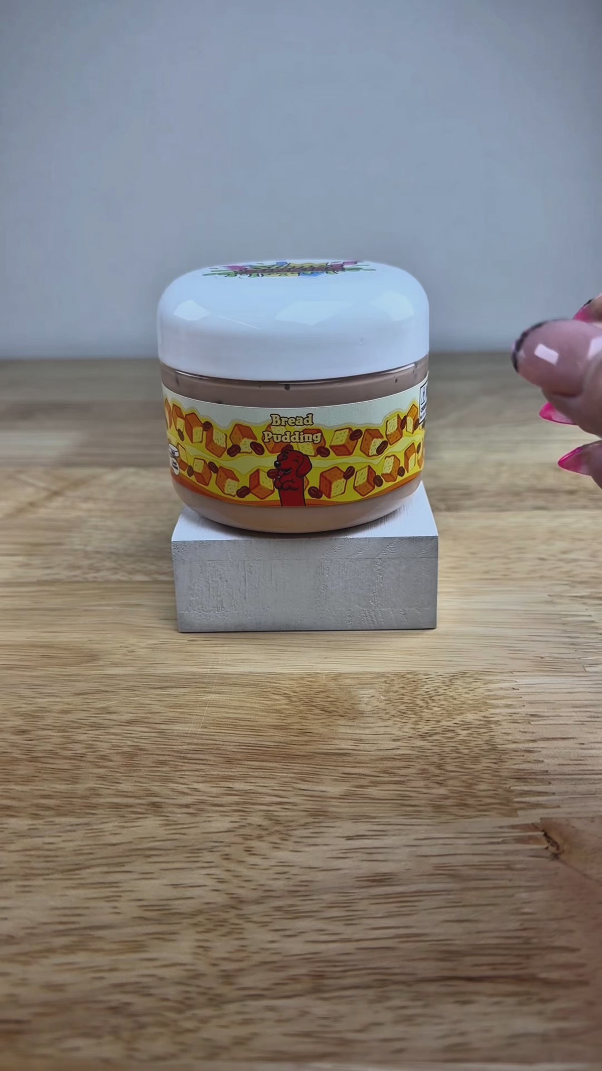 bread pudding tan slime with dark brown pebbles in a clear jar with a bread pudding label with bread raisins and a dog